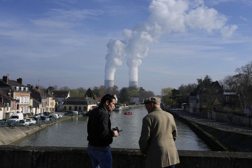 Gendarme patrol on the Seine river, with the Nogent-sur-Seine nuclear plant in background