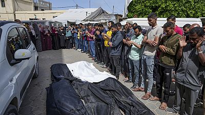 Mourners pray over the bodies of Palestinians who were killed in an Israeli airstrike in Nuseirat, at the Al Aqsa hospital in  Gaza Strip, Saturday, April 27, 2024