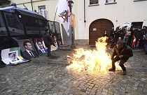 Protesters light fire before burning giant photographs of leaders, Turin, Italy, Sunday, April 28, 2024. 