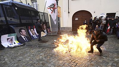 Protesters light fire before burning giant photographs of leaders, Turin, Italy, Sunday, April 28, 2024. 