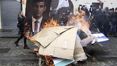 Manifestantes queman una fotografía del primer ministro británico Rishi Sunak durante una manifestación contra la cumbre de ministros de Medioambiente del G7 en Venaria Reale.