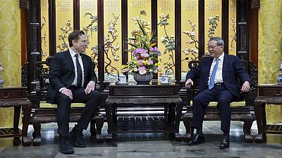 In this photo released by Xinhua News Agency, visiting Tesla founder and CEO Elon Musk, left, meets with Chinese Premier Li Qiang in Beijing, Sunday, April 28, 2024. 