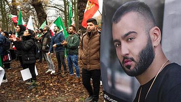 O rapper iraniano Toomaj Salehi condenado à morte — retratado aqui: Manifestantes em apoio a Salehi em Haia, Holanda.