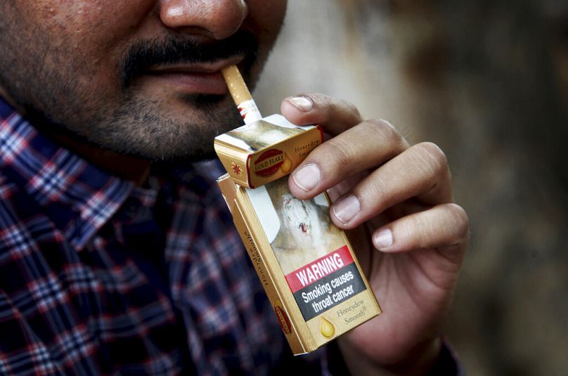 A man takes a cigarette from a pack in New Delhi, November 2016