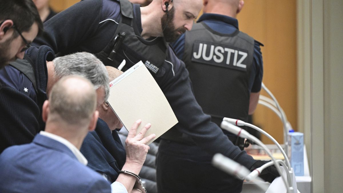 A defendant is led into the courtroom, at the Higher Regional Court at the start of a trial, in Stuttgart, Germany, Monday, April 29, 2024. 