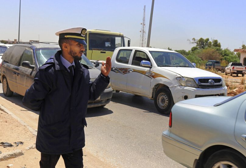 a police officer waves vehicles through a checkpoint during rush hour in Benghazi, May 2019