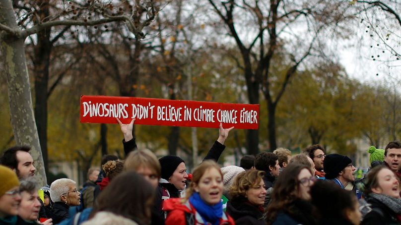 Activistas pelo clima manifestam-se com uma faixa junto à Torre Eiffel, em Paris, em dezembro de 2015, durante a cimeira COP21.