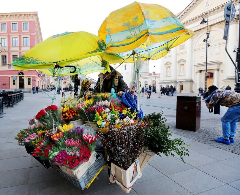 FILE - A street seller pulls a bike selling flowers in the old town on Easter Day in Warsaw, Poland, Sunday, March 27, 2016.