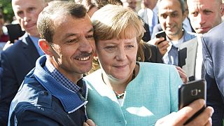 German chancellor Angela Merkel poses for a selfie with a refugee in a facility for arriving refugees in Berlin. 9 Sept. 2015.