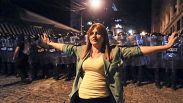 Ein Demonstrant steht zwischen oppositionellen Demonstranten, die sich versammeln, um am 30. April 2024 in Tiflis gegen das „russische Gesetz“ zu protestieren