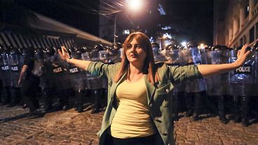 Демонстрант стоит между протестующими оппозиции, собравшимися в знак протеста против «российского закона» в Тбилиси, 30 апреля 2024 года
