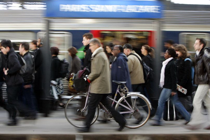 A commuter walks with his bike alongside a train at Paris' Saint Lazare, March 2009