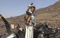 un caza hutí celebra frente a lo que, según dijeron, escombros de un vehículo aéreo estadounidense MQ9, derribado por la defensa aérea en Saada, el 26 de abril de 2024