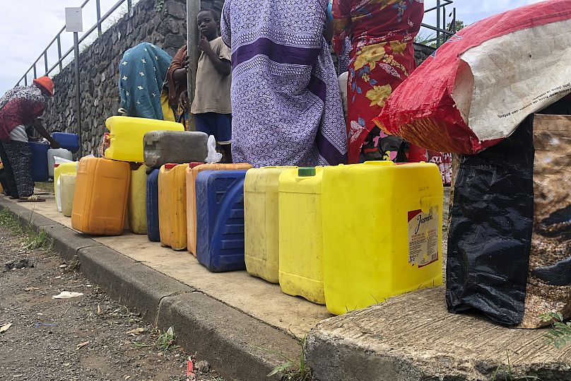 People queue to fill up containers with water in Tsoundzou, Mayotte, Saturday February 6, 2021 during the COVID-19 pandemic.