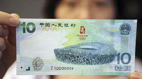 Kínai nő egy 10 jüanos bankjeggyel