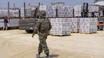An Israeli soldier walks through an inspection area for trucks carrying humanitarian aid supplies bound for Gaza