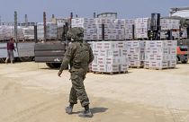 An Israeli soldier walks through an inspection area for trucks carrying humanitarian aid supplies bound for Gaza