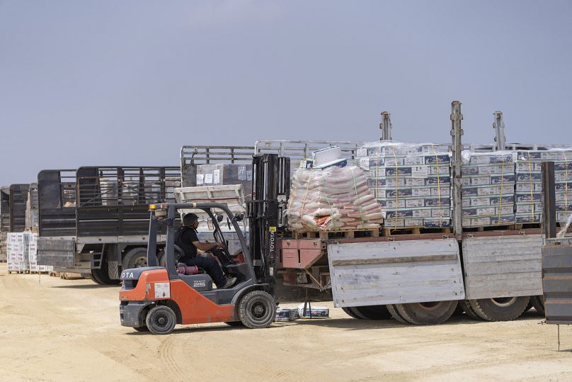 A worker moves a pallet in an inspection area for trucks carrying humanitarian aid supplies bound for Gaza