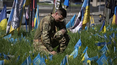 جندي أوكراني في ميدان الاستقلال محاط بأعلام وطنية صغيرة ترمز إلى الجنود الأوكرانيين الذين قتلوا في الحرب مع روسيا، كييف، أوكرانيا- 1 مايو 2024.
