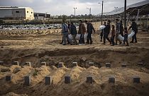 فلسطينيون يحملون جثث أقاربهم الذين قتلوا في القصف الإسرائيلي لقطاع غزة، خلال جنازتهم في مقبرة في رفح، جنوب غزة