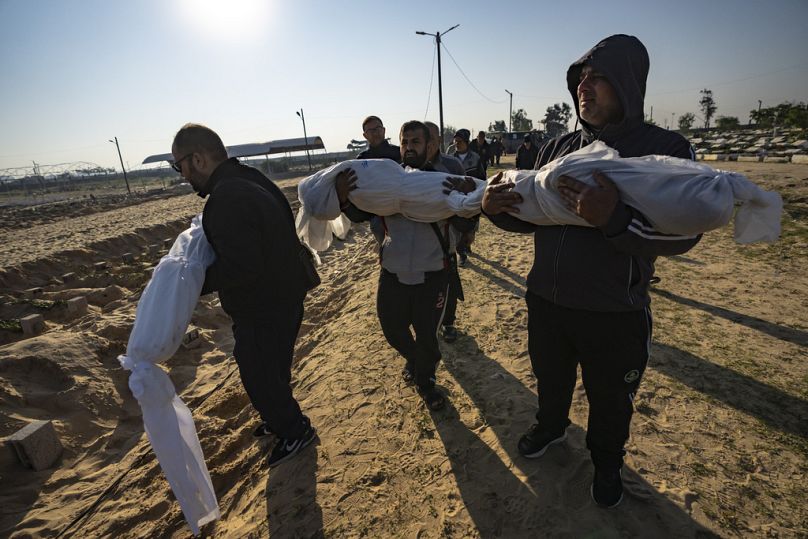 فلسطينيون يحملون جثث أقاربهم الذين قتلوا في القصف الإسرائيلي لقطاع غزة، خلال جنازتهم في مقبرة في رفح، جنوب غزة