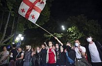 Demonstrators wave a Georgian national flag standing in front of police block during an opposition protest against a bill in Tbilisi, Georgia, on May 2, 2024.