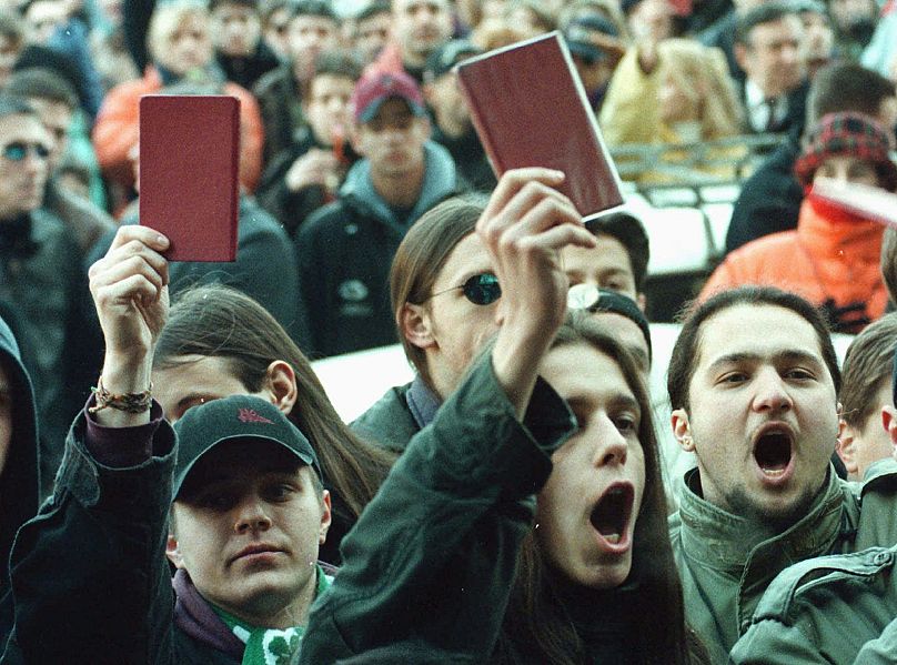 Students hold report cards during a protest in central Belgrade Monday Feb. 3 1997, thousands of students walked the streets of Belgrade