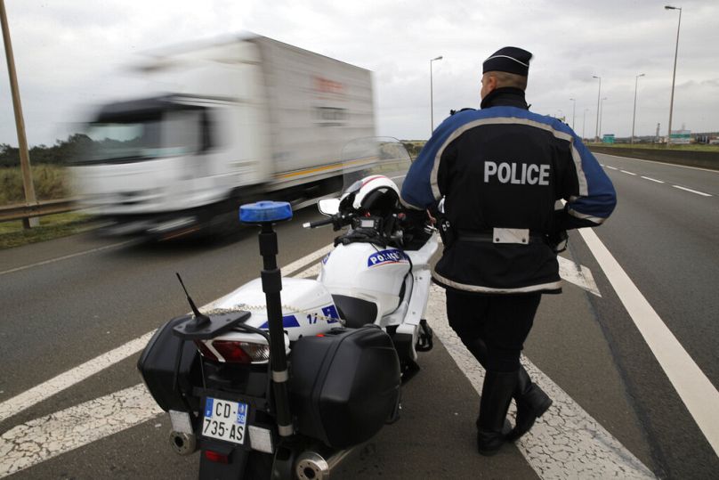 A police officers guard the motorway leading to the ferry port in Calais, northern France in this file image