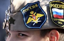 A boy wears Russian insignia on his hat, 12 March 2022