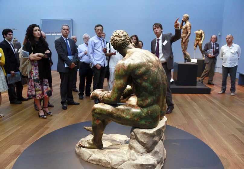 Visitors gather around a sculpture titled "Terme Boxer, 3rd–2nd century B.C." at J. Paul Getty Museum, 27 July 2015.