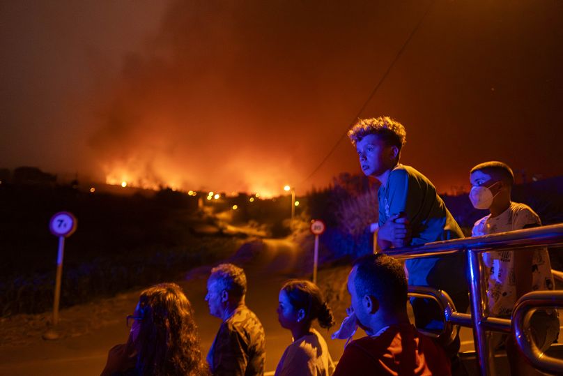 Residents are blocked by police as they try to reach their houses in Benijos village as a wildfire advances in La Orotava in Tenerife, August 2023
