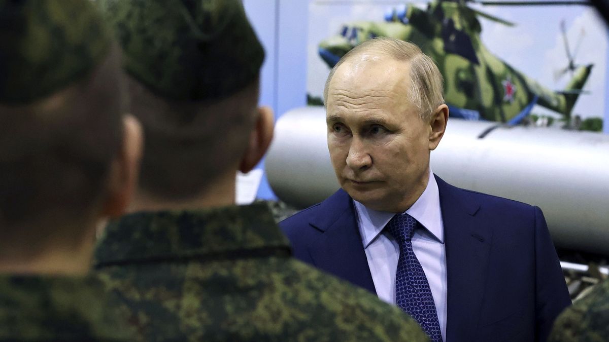 Президент Владимир Путин с российскими военными на фоне боевой техники
