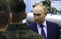 Президент Владимир Путин с российскими военными на фоне боевой техники