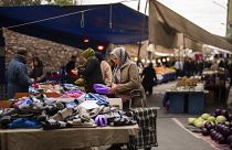 People buy goods and food at a street market in Istanbul (file photo)