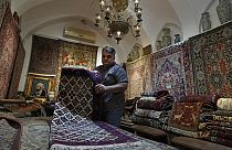 Iranian carpet shop owner Ali Faez works at his shop at the traditional bazaar of the city of Kashan, about 152 miles (245 km) south of the capital Tehran, Iran.