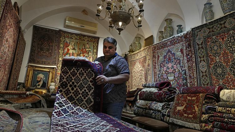 Iranian carpet shop owner Ali Faez works at his shop at the traditional bazaar of the city of Kashan, about 152 miles (245 km) south of the capital Tehran, Iran.