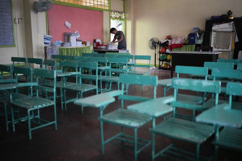 A teacher arranges papers at an empty classroom as classes shifted to online mode at the Justo Lukban Elementary School in Manila, Philippines.