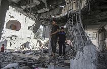 Los palestinos permanecen en las ruinas de la casa de la familia Chahine, tras un ataque israelí nocturno en Rafah, en el sur de la Franja de Gaza, el viernes 3 de mayo de 2024.