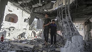 Palestinians stand in the ruins of the Chahine family home, after an overnight Israeli strike in Rafah, southern Gaza Strip, Friday, May 3, 2024.