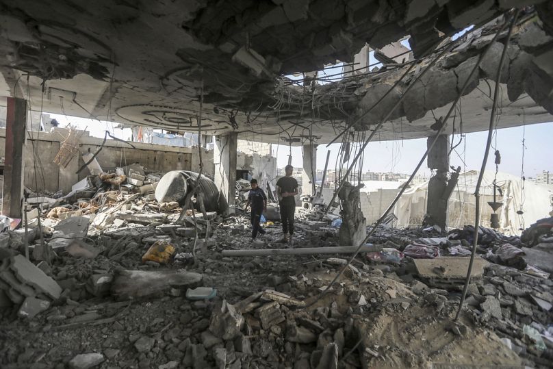Palestinos en las ruinas de la casa de la familia Chahine, tras un ataque israelí nocturno en Rafah, sur de la Franja de Gaza, viernes 3 de mayo de 2024.