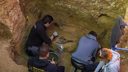 Voluntarios trabajan junto al esqueleto de una víctima antes de su exhumación en una fosa común en una excavación de la Asociación para la Recuperación de la Memoria Histórica