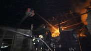 Bomberos intentando apagar el fuego en Járkov tras un ataque ruso