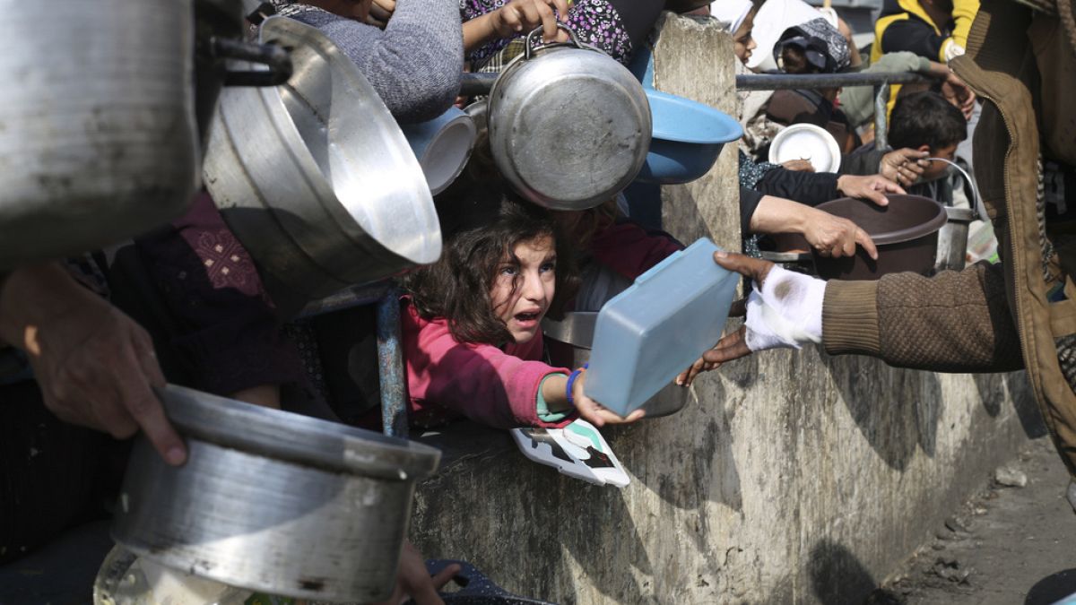 Les Palestiniens font la queue pour obtenir de la nourriture gratuite pendant l'offensive aérienne et terrestre israélienne sur la bande de Gaza à Rafah, le 9 janvier 2024.