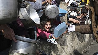 Les Palestiniens font la queue pour obtenir de la nourriture gratuite pendant l'offensive aérienne et terrestre israélienne sur la bande de Gaza à Rafah, le 9 janvier 2024.