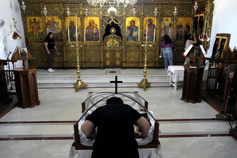 Православный верующий целует икону, изображающую подготовку Иисуса Христа к погребению, в монастыре Апостолос Андреас на полуострове Карпасия на Кипре