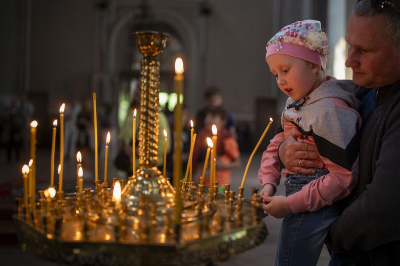 Believers light candles after a cake and Easter egg blessing ceremony at the Orthodox Church of the Holy Spirit in Vilnius, Lithuania, Saturday, May 4, 2024