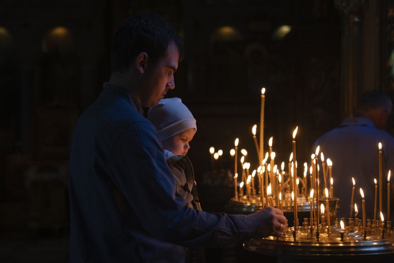 People light candles as they pray in St. Volodymyr Cathedral on Easter Eve in Kyiv, Ukraine, Saturday, May 4, 2024.
