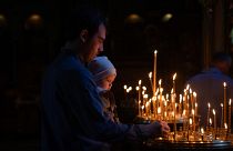 Люди зажигают свечи во время молитвы во Владимирском соборе в Киеве в Великую субботу, 4 мая 2024 года