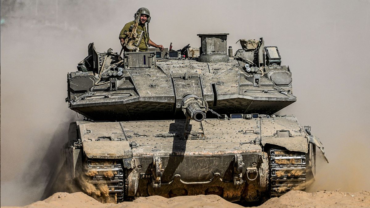 Israeli soldiers drive a tank at a staging ground near the border with the Gaza Strip, 5 May 2024
