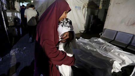سيدة فلسطينية من عائلة قشطة، تحمل جثان طفلها هاني البالغ 7 أشهر الذي قتل في غارة إسرائيلية استهدفت منزلهم في رفح 6/5/2024